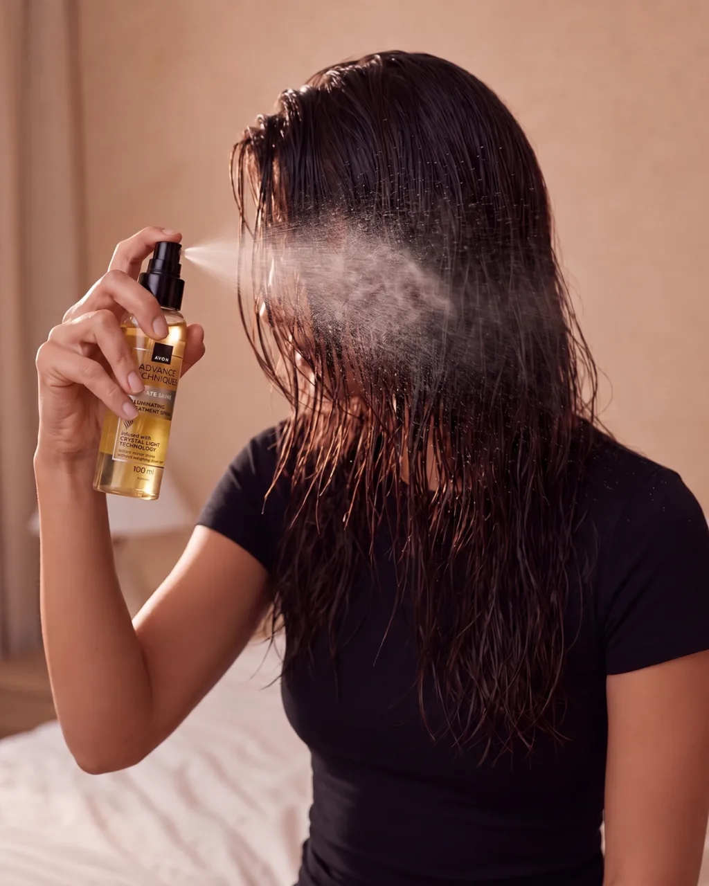 Spraying hair oil, seen from behind