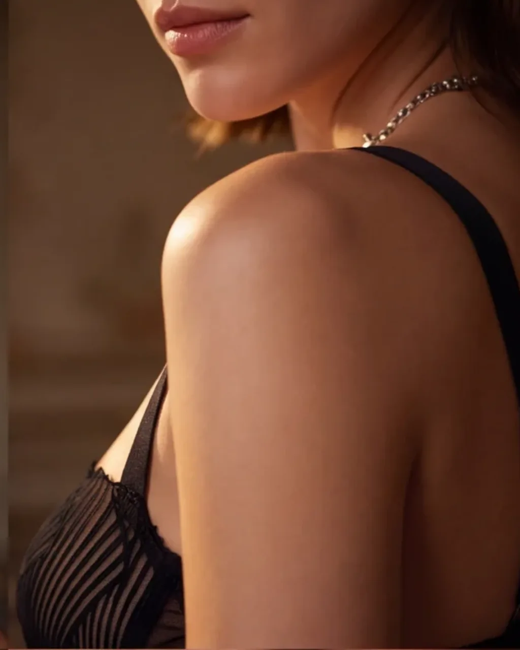 Shoulder and strap in window light