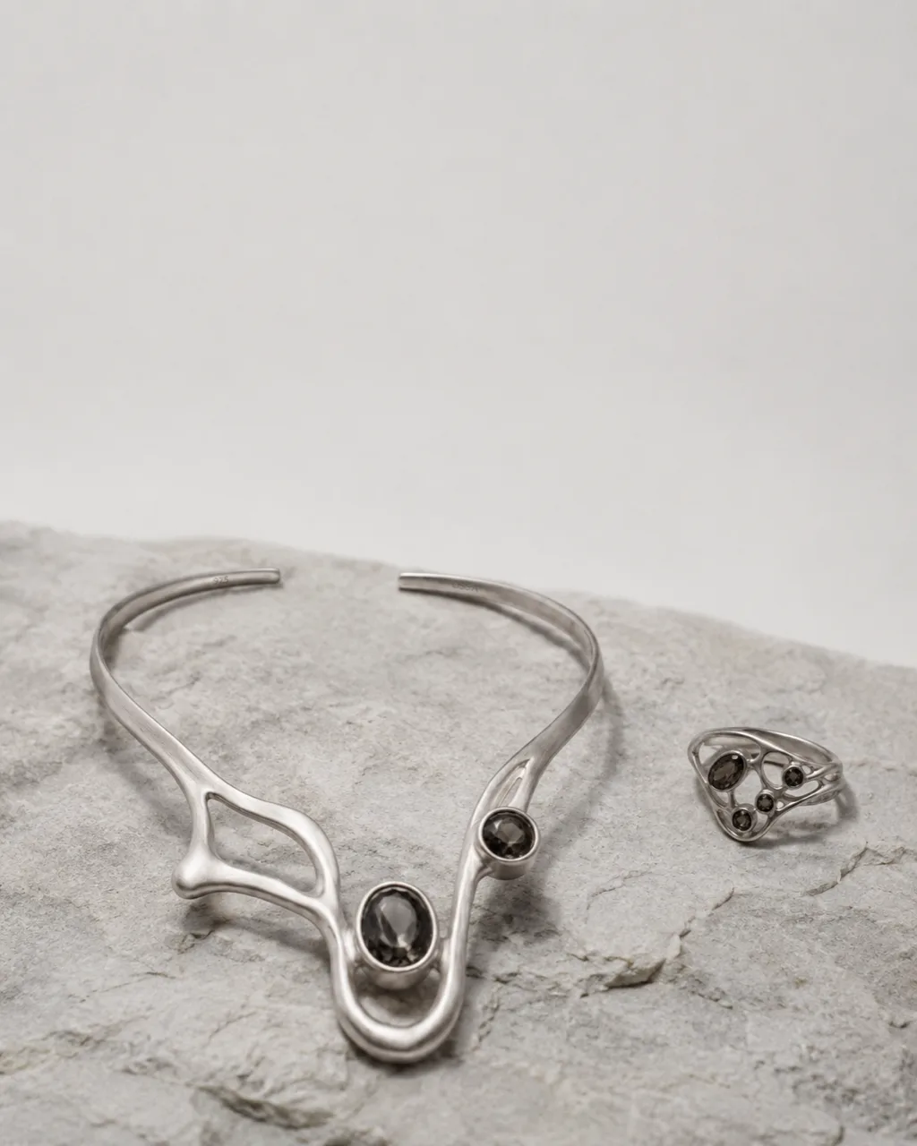 OSSA necklace and ring resting on pale stone