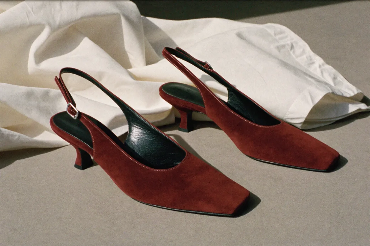 Burgundy suede slingback heels beside a cream dust bag, AI concept work