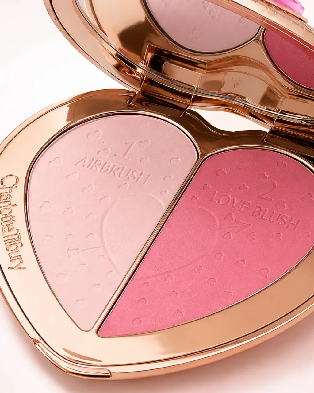 Charlotte Tilbury: an open heart-shaped compact with two pink powders, labelled Airbrush and Love Blush, AI concept work