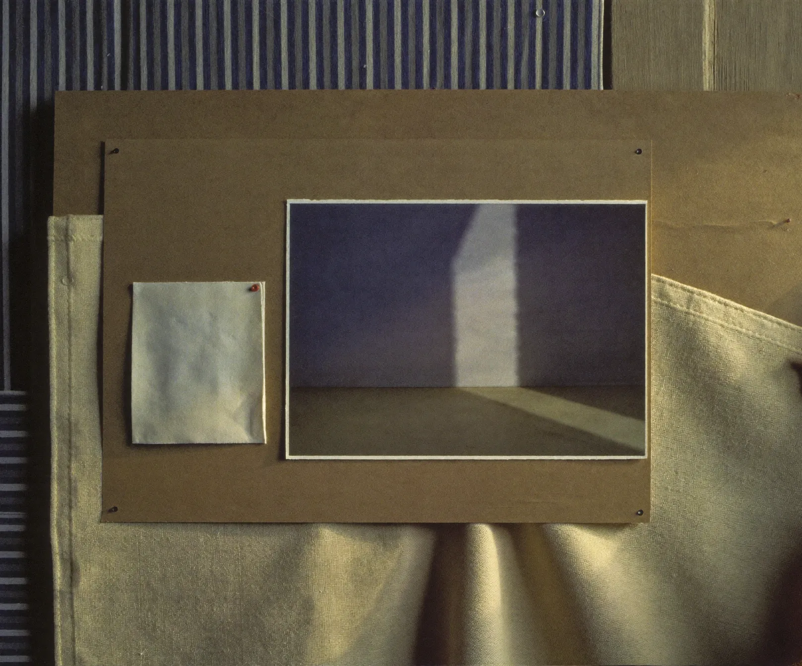 A moodboard on kraft board: a print of an empty room crossed by light and a blank card, over striped fabric, AI concept work
