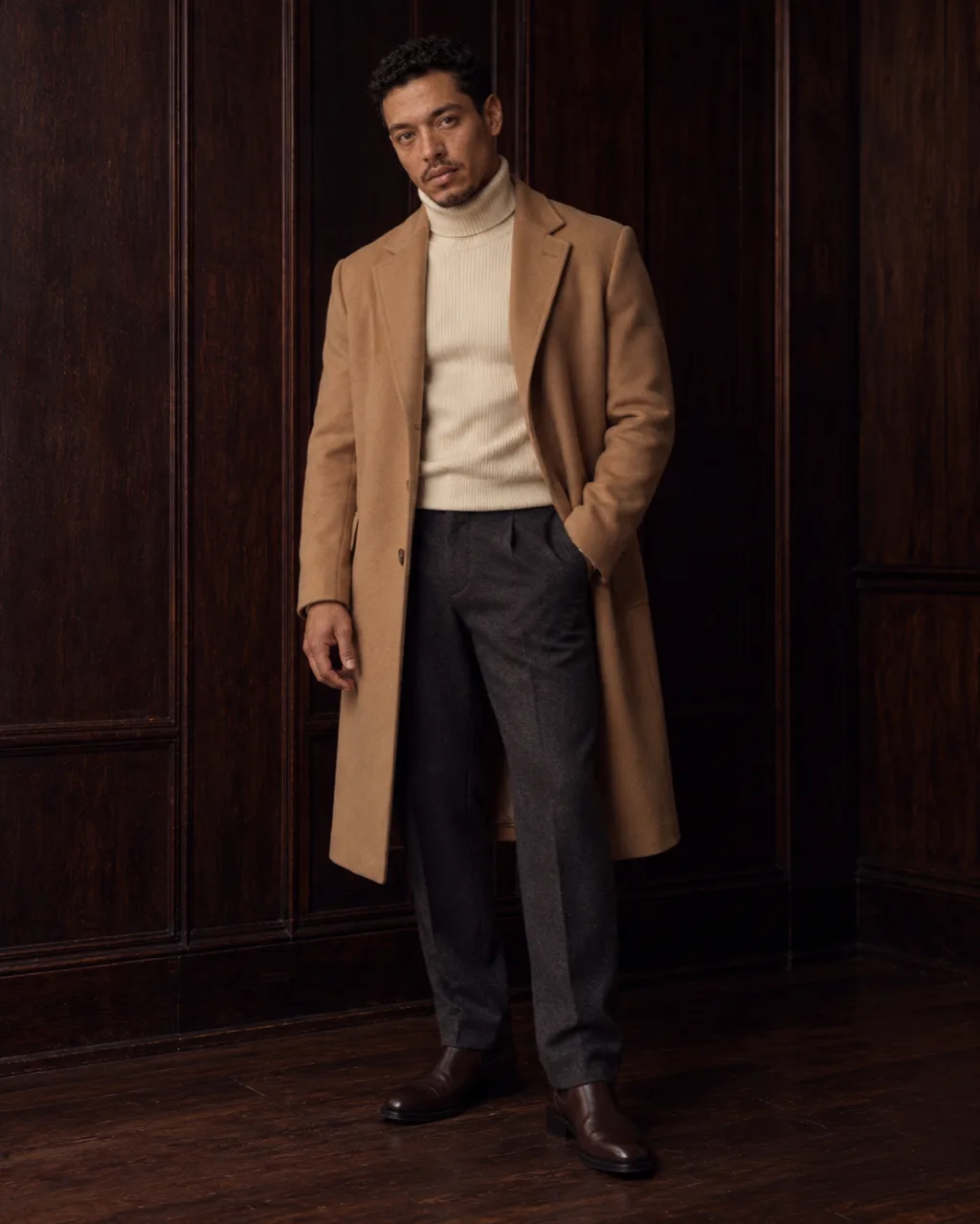 Sunderly look 3, camel coat over a cream roll-neck: full length from the front in a wood-panelled room, AI concept work