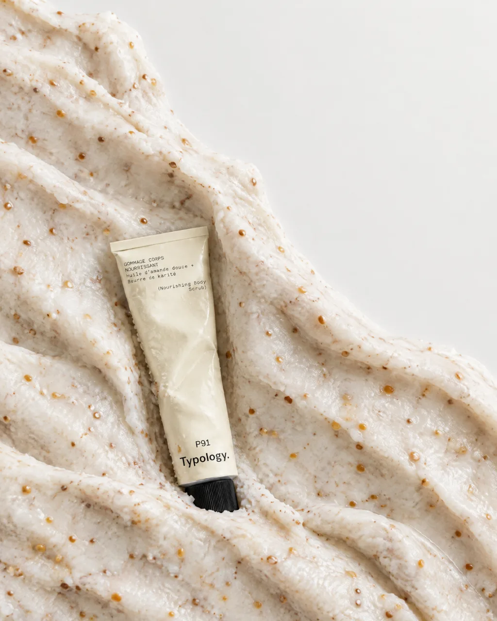 Typology P91 body scrub tube nestled in a mound of exfoliating scrub, AI concept work